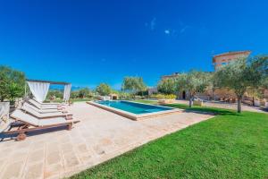 una piscina en un patio con 2 tumbonas en Finca Son Colom, en Manacor