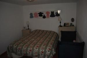 um quarto com uma cama e uma prateleira de roupas em Casa típica alentejana em Alpalhão