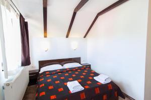 a bedroom with a bed with a black and orange comforter at Casa Thomas Bran in Bran