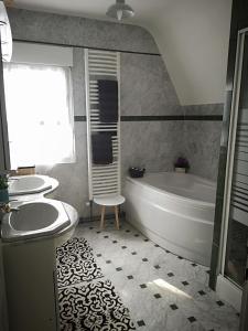 ein Badezimmer mit Badewanne und Waschbecken in der Unterkunft la Maison de Lilly in Pierry