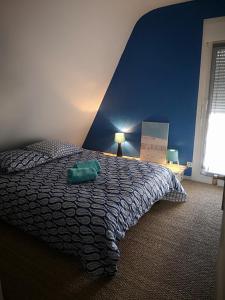 ein Schlafzimmer mit einem Bett mit einer blauen Wand in der Unterkunft la Maison de Lilly in Pierry