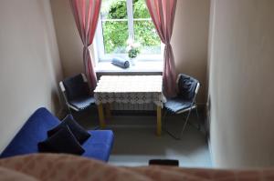 a table and two chairs in a room with a window at Rooms Close To Everywhere in Gdańsk