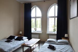 two beds in a room with two windows at Rooms Close To Everywhere in Gdańsk