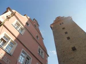 un edificio alto de ladrillo con una torre de reloj al lado en Hotel Turmdieb en Volkach