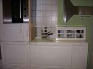 a kitchen with white cabinets and a microwave at Wohnpark Schwarzwaldblick Bernau in Bernau im Schwarzwald