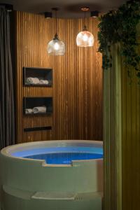 een badkamer met een bad en 2 hanglampen bij Little Dubai in Belgrado