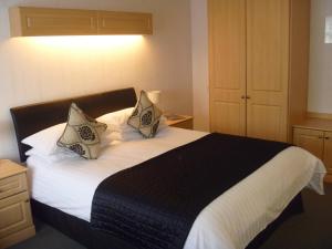 a bedroom with a large bed with two pillows at Deanwater Hotel in Wilmslow