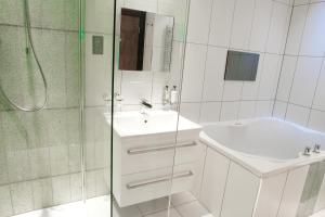 y baño blanco con lavabo y ducha. en Windermere Suites en Windermere