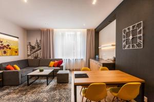 uma sala de estar com um sofá, uma mesa e cadeiras em K4 APARTHOTEL KRAKÓW na Cracóvia