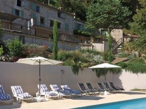 a group of chairs and umbrellas next to a pool at Luxury country house with heated private pool in Courniou