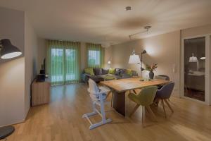 a living room with a table and chairs and a couch at FeWo "Staufen Lodge" Oberstaufen in Oberstaufen