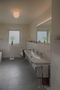 La grande salle de bains est pourvue d'un lavabo et d'un miroir. dans l'établissement FeWo "Staufen Lodge" Oberstaufen, à Oberstaufen