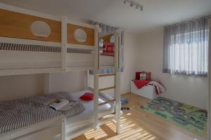 a bedroom with two bunk beds and a ladder at FeWo "Staufen Lodge" Oberstaufen in Oberstaufen