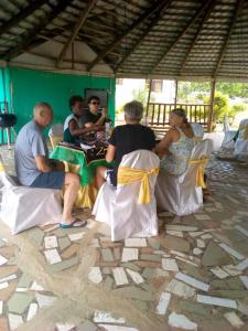 a group of people sitting around a table in a tent at Abuesi Beach Resort in Takoradi