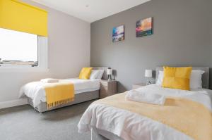 a bedroom with two beds and a window at Dalkeith Three Bed Two Bath Apartment in Dalkeith