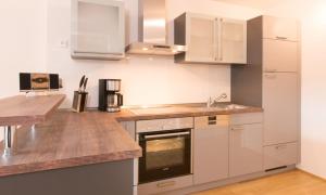 a kitchen with white appliances and a wooden counter top at FeWo "Staufner Domizil" Oberstaufen in Oberstaufen