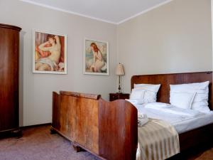1 dormitorio con 1 cama de madera y 2 cuadros en la pared en Leniwka, en Świebodzin