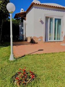 una casa con un palo della luce e fiori nell'erba di Villa Joyosa Apartments a Ischia