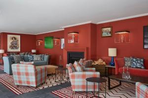 a living room with red walls and couches and a fireplace at Machrie Hotel & Golf Links in Port Ellen
