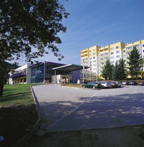 ein Parkplatz vor einem großen Gebäude in der Unterkunft Morada Hotel Alexisbad in Alexisbad