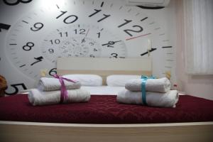 um quarto com uma cama com um grande relógio na parede em Alindro City Center Apartment em Tirana
