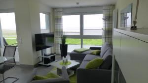 ein Wohnzimmer mit einem Sofa und einem TV in der Unterkunft Residenz Windjammer Whg 12 in Cuxhaven