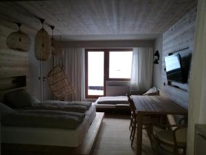 クライナルにあるFerienwohungen Wedlのベッド2台、ソファ、テレビが備わる客室です。