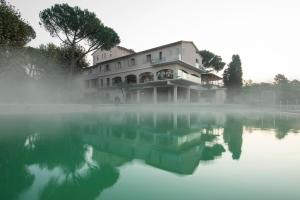 a large body of water in front of a house at Albergo Posta Marcucci in Bagno Vignoni
