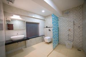 a bathroom with a sink and a shower and a toilet at Hotel President in Madurai