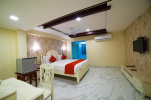 um quarto de hotel com uma cama e uma televisão em Hotel President em Madurai