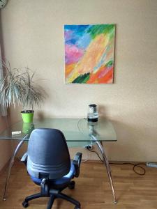 a desk with a chair and a painting on the wall at Alaska Fox in Kyiv