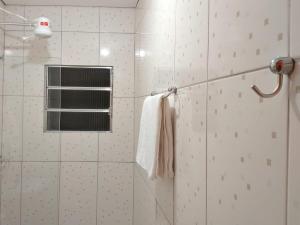 a bathroom with a shower with a window and a towel at HOTEL KISS - TABOÃO DA SERRA in Taboão da Serra