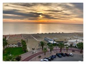 a group of cars parked in a parking lot near the ocean at Aurea Hotel in Tortoreto Lido