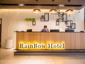una persona seduta in un hotel di uvetta bow di Rainbow Hotel a Magong