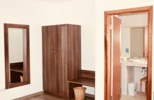 a bathroom with a mirror and a sink at Hotel Schweizerhaus/Cafe Anton in Swakopmund