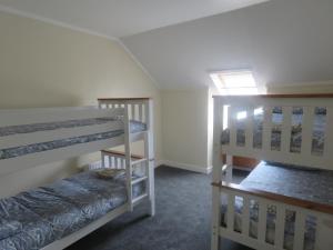 a room with three bunk beds and a window at Cunninghame House in Beith