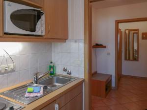 eine Küche mit einer Spüle und einer Mikrowelle in der Unterkunft Ferienappartements Elbaussicht - Krippen in Bad Schandau