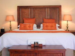a bedroom with a large bed with orange pillows at Ubuntu Bed and Breakfast in Marloth Park +20 photos