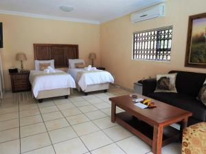 a living room with two beds and a couch at Ubuntu Bed and Breakfast in Marloth Park +20 photos