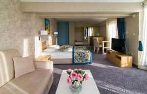 a hotel room with a bed and a couch at Plaza Hotel in Varna City