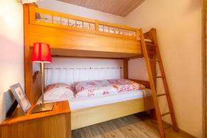 ボルシュターラングにあるFerienwohnungen Alpentraum - Hörnernestのベッドルーム1室(二段ベッド2台、ランプ付きデスク付)が備わります。