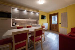 een keuken met een tafel en stoelen in een kamer bij Baita Belvedere - Appartamenti Abar in Livigno