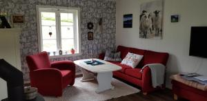 a living room with a couch and two chairs and a table at Kårboligen in Bøstad