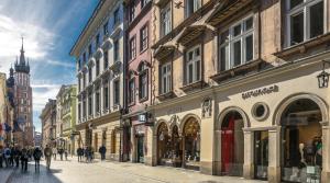 un grupo de personas caminando por una calle con edificios en Apartments Legendary Kraków, en Cracovia