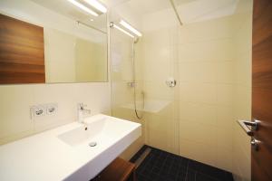 a white bathroom with a sink and a shower at Seehof Innsbruck in Innsbruck