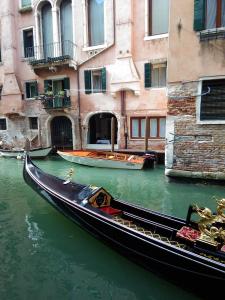una góndola estacionada en un canal frente a un edificio en Casa Marco Polo, en Venecia