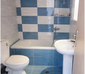 a blue and white bathroom with a toilet and a sink at 4S Beach Superior Apartments in Stalida +77 photos