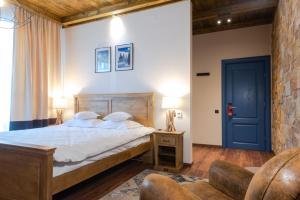 a bedroom with a bed and a blue door at KABAN BOUTIQUE HOTEL - 5Star Central Villa in Vatra Dornei in Vatra Dornei