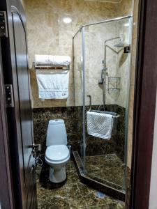 a bathroom with a toilet and a glass shower at Georgia Hotel in Yerevan