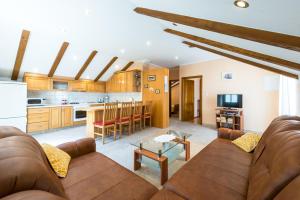 ein Wohnzimmer mit Sofa und eine Küche in der Unterkunft Apartments Villa Kulish in Cavtat